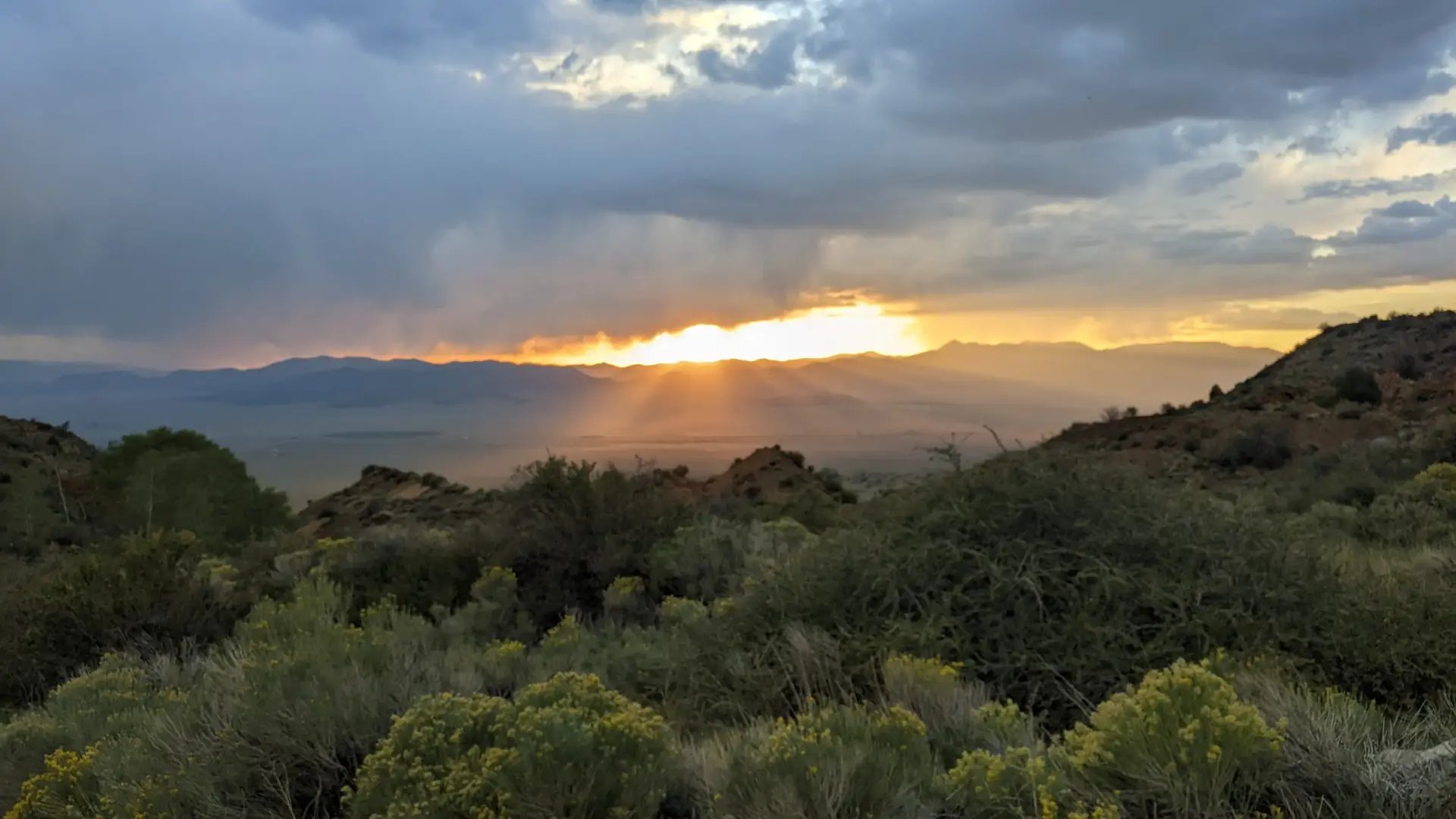 The sun peeking through the clouds over the Sangre de Cristo mountain range
