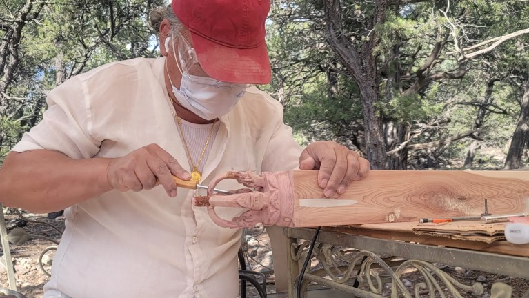 Sangha member carving wood totem for the contents of the Stupa